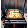 Cooking eggs and bacon on a plancha
