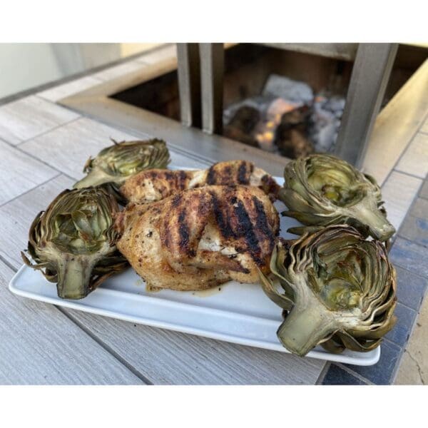 Grilled chicken halves roasted over a wood fire on an Argentinian grill