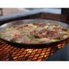 Cooking food on cast iron pan on an Argentine grill