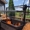 A Santa Maria grill with a wood fire in the firebox before cooking.