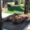 Wood grill with grill surface that moves up and down.